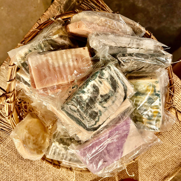 Assorted soaps in clear plastic packaging on a woven basket